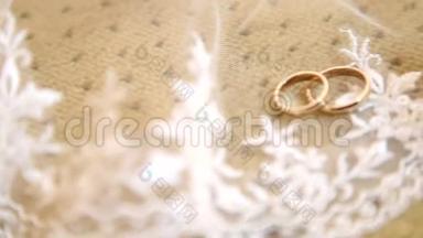 新娘的白色面纱上戴着两枚金色结婚戒指。 面纱上有两枚结婚戒指。 面纱上戴着结婚戒指。
